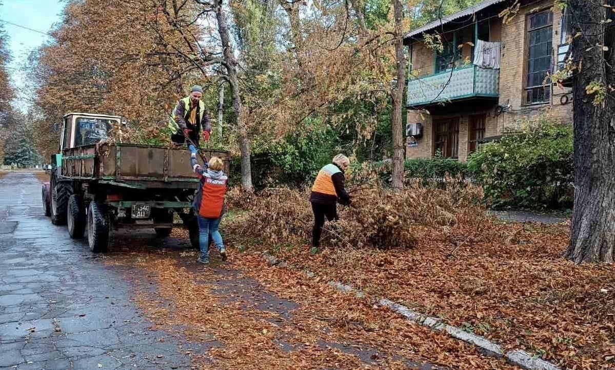 комунальники прибирають опале листя, осінь