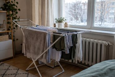 Сушарка з білизною біля вікна в квартирі взимку